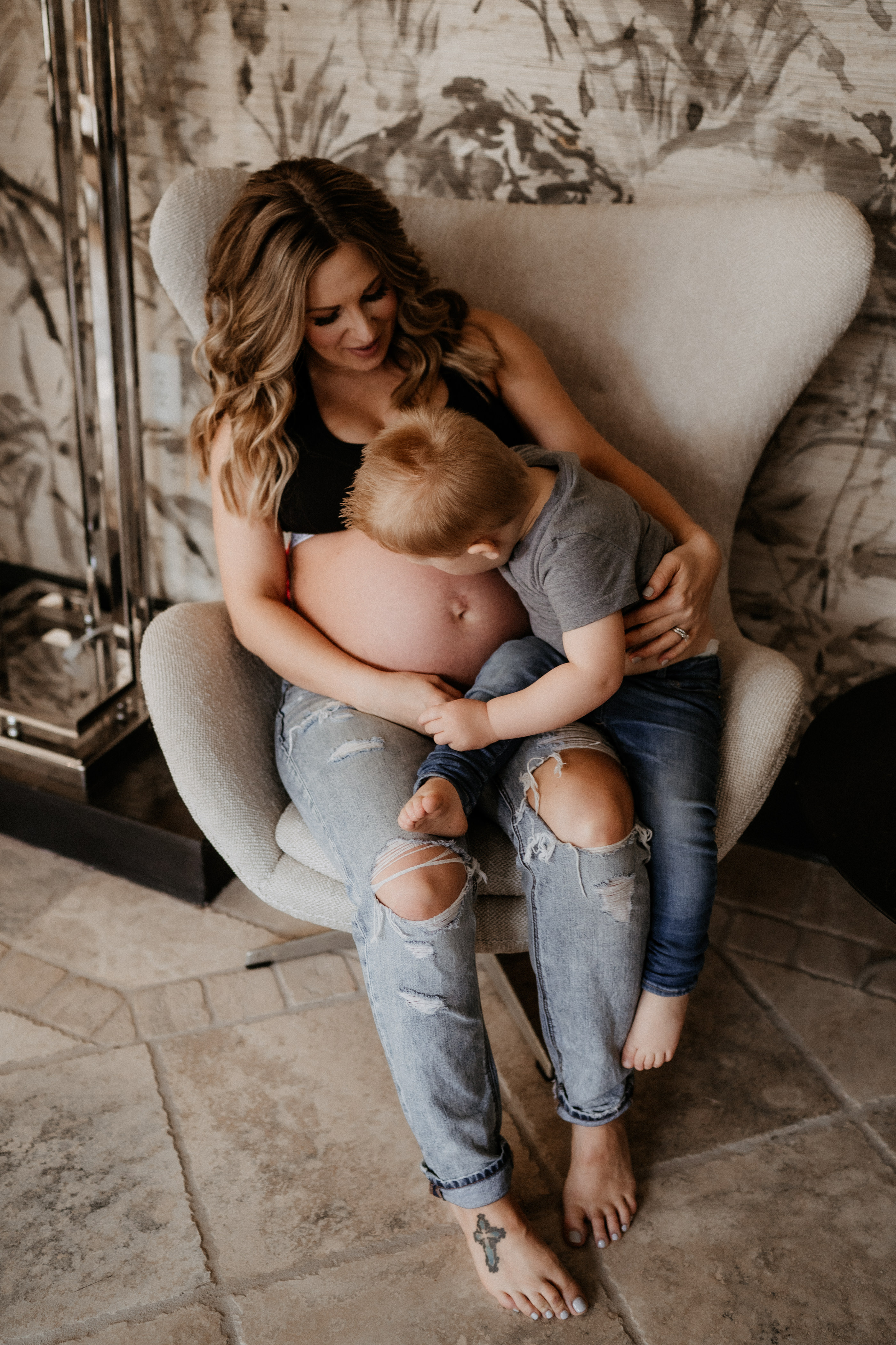 Intimate in-home maternity photography, toddler kissing mamas belly
